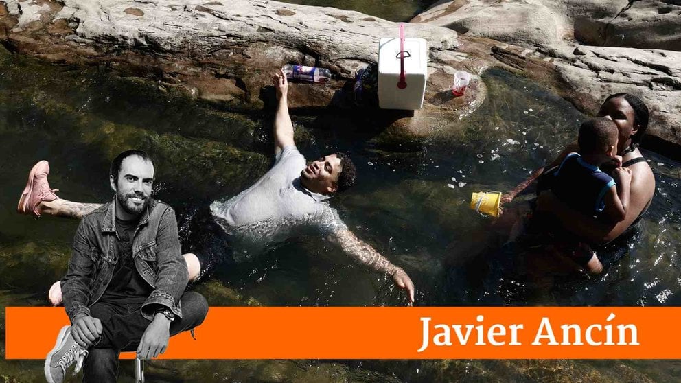 Dos personas se refrescan en el río Arga a su paso por Huarte. JESÚS DIGES / EFE